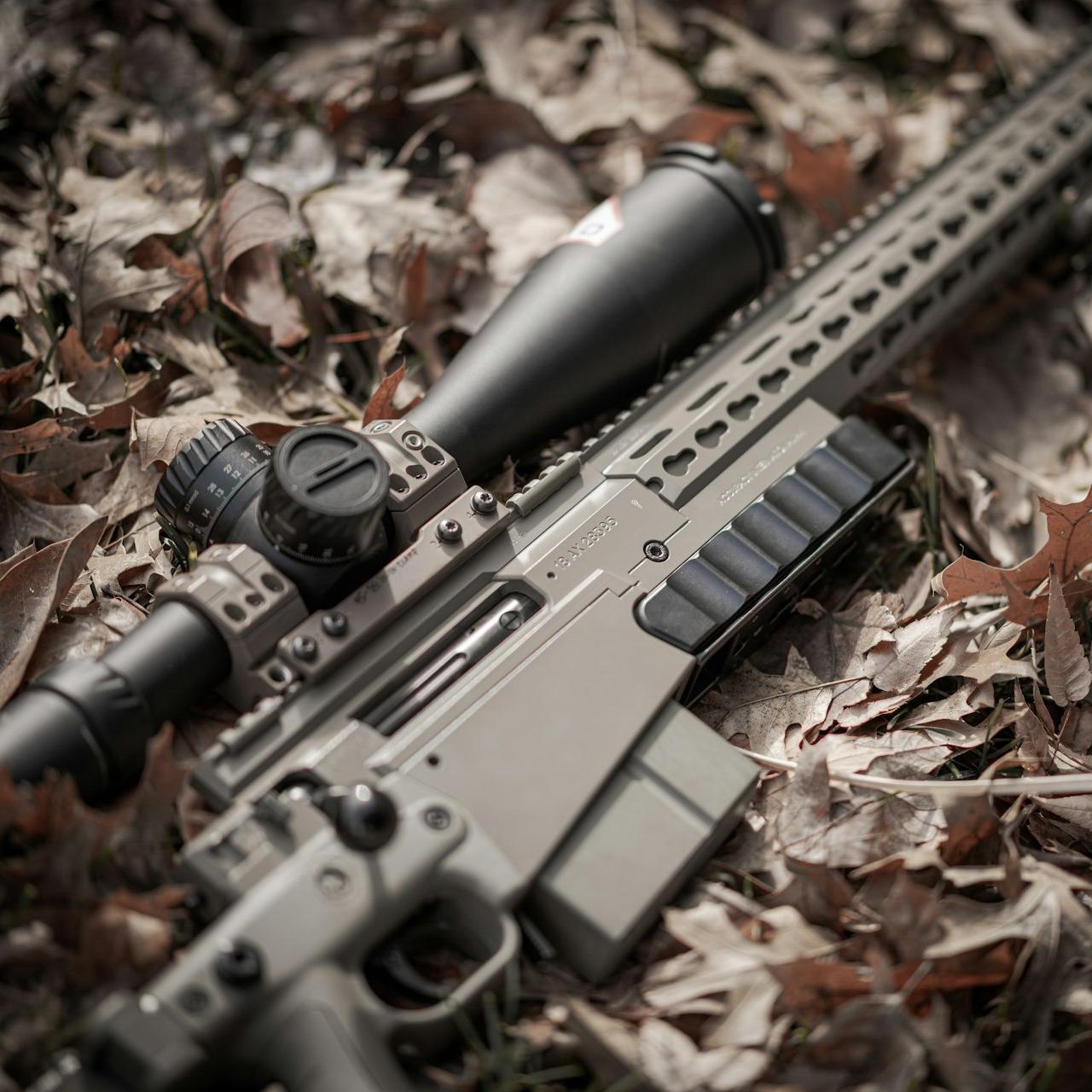 a rifle laying on the ground with a scope